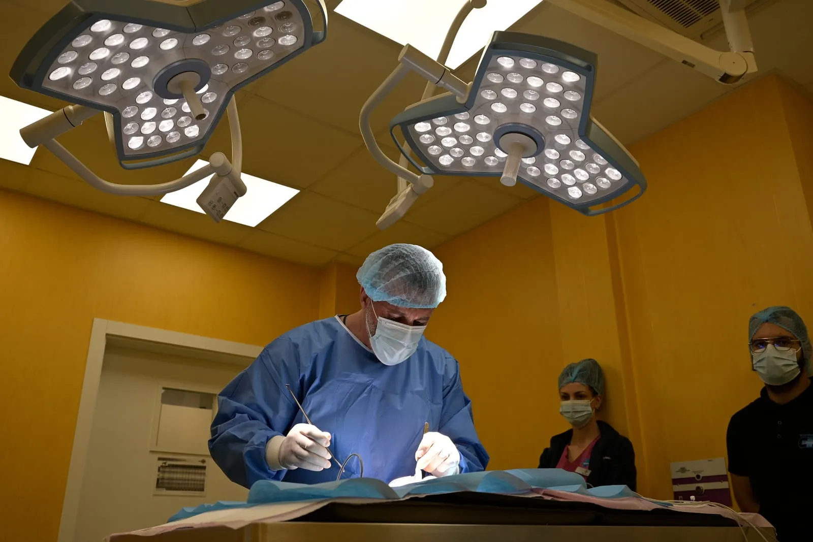 Surgery at the clinic: a surgeon and two assistants.
